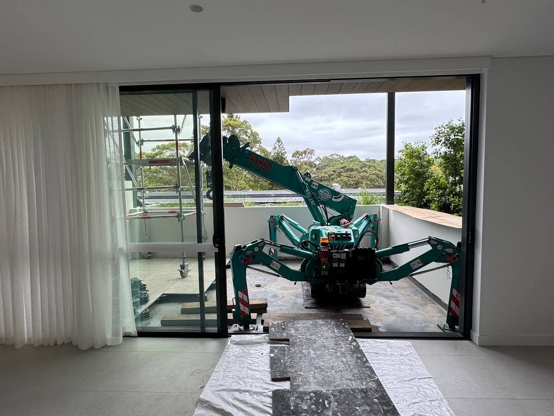 Mini crane positioned on a residential balcony through sliding doors